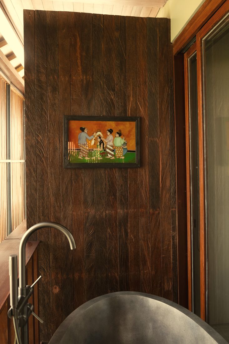 Freestanding stone tub beside an ironwood wall